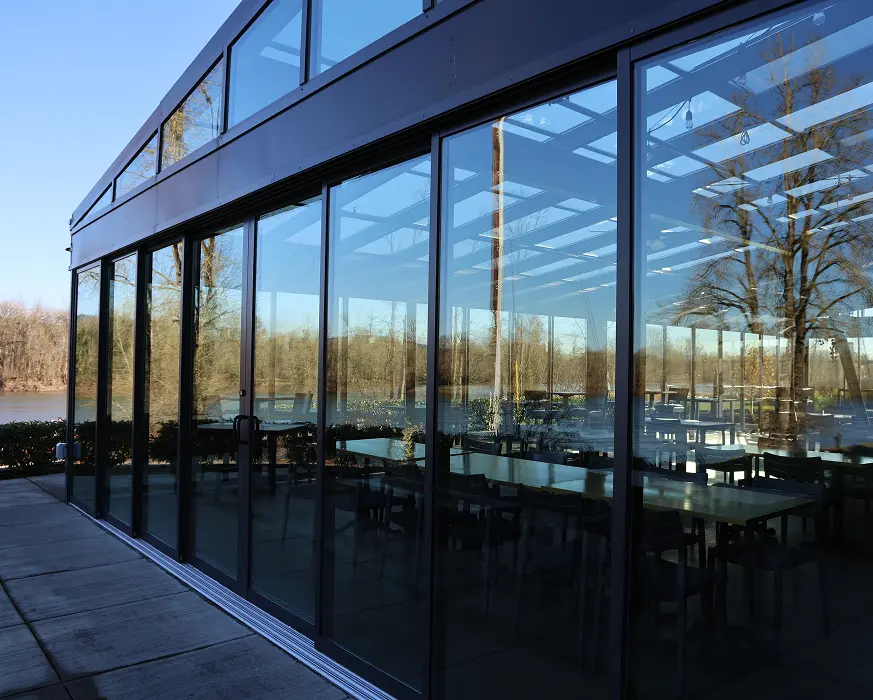 Glass conservatory with aluminum frame attached to residential home